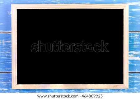 Blank blackboard on wooden table.Template mock up for adding your design and leave space beside frame for adding more text