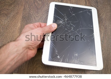 Man's hand  holds tablet PC with broken touchscreen