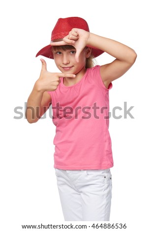 Lovely little girl wearing traveler hat making frame with her hands, over white background