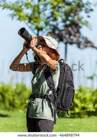 Professional nature photographer lady with her camera in the field