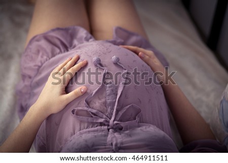 stomach of pregnant woman with hands close up
