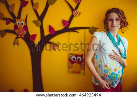 pregnant woman standing near the beautiful wall