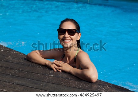 Woman in swimming pool. Happy  girl enjoying summer sun in a hotel pool or water park. Summer vacation concept.