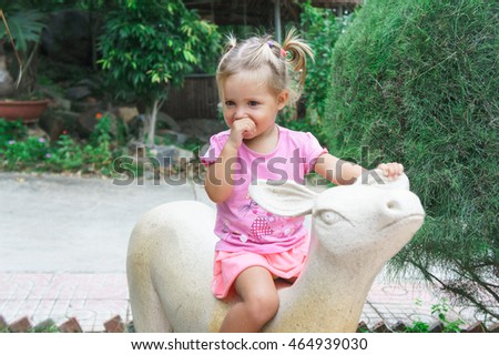 little girl rides a toy deer.