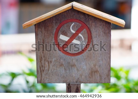 No smoking sign against a wood wall. The white non-smoking sign on the wooden floor is a sign that the traveler is aware of being a non-smoker. .Non Smoking sign on pole