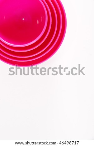 Pink plastic baking utensils isolated on a white background