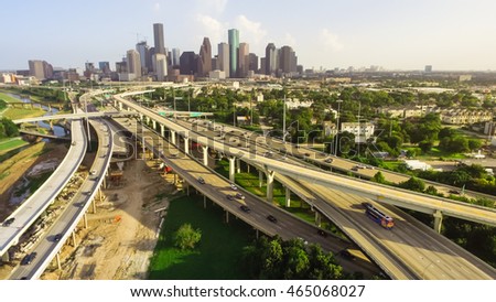 Panorama aerial view downtown and interstate I45 highway with massive intersection, stack interchange, road junction and elevated road construction at sunset from northwest side of Houston, Texas, USA