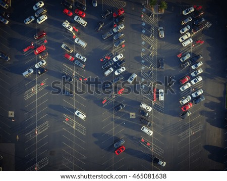 Top view parking lots with rows of parked car, shopping carts, road sign for disabled drivers at a supermarket in Houston, Texas, USA at sunset.Urban infrastructure and transportation concept. Vintage