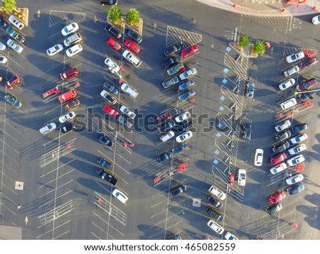 Top view parking lots with rows of parked car, shopping carts, road sign for disabled drivers at a supermarket in Houston, Texas, USA at sunset. Urban infrastructure and transportation concept