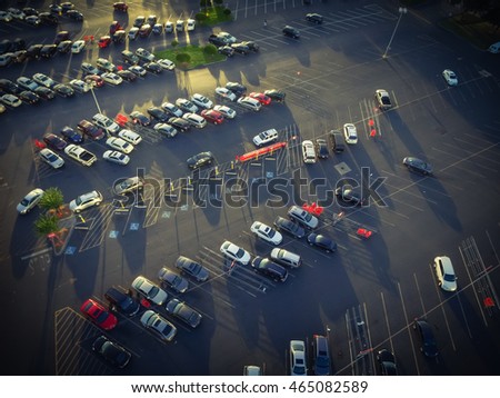 Top view parking lots with rows of parked car, shopping carts, road sign for disabled drivers at a supermarket in Houston, Texas, USA at sunset.Urban infrastructure and transportation concept. Vintage