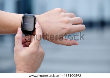 Smart watch with blank screen outdoors on urban background