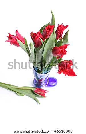 Red tulips in dark blue vase in the form of boot