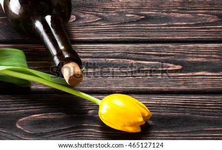 Tulip and wine on wood background