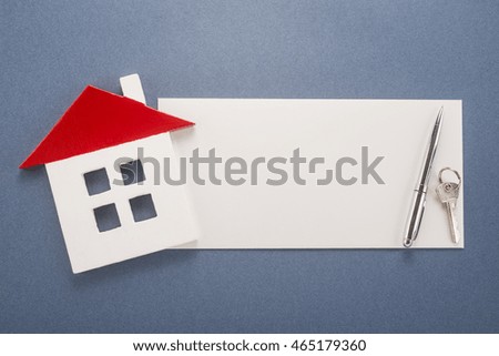 Blank paper, pen, key and house on blue background 