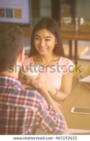 Toned image of romantic couple in love having date. Man and woman sitting face to face and drinking delicious coffee in restaurant or cafe.