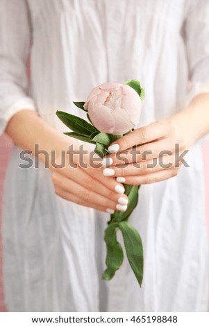 Woman holding beautiful peony, closeup