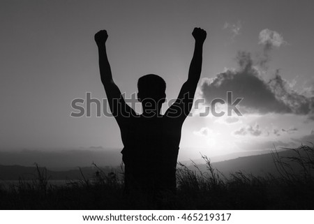 Young man with arms in the air celebrating. People winning feeling happy and free. 