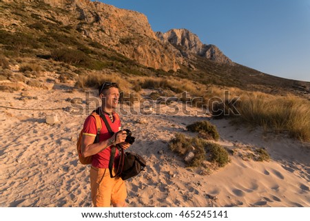 man taking a picture of the landscape against the sea