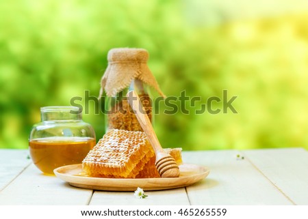 Bee products with honey, sweet honeycomb and bee pollen on a wooden background, healthy products by organic natural ingredients concept
