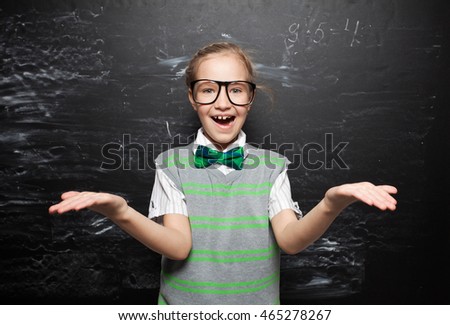 Child in school. Girl near blackboard. Education