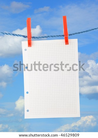 Blank piece of paper hang on clothesline on sky background