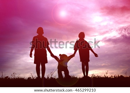 Silhouette children with teddy bear on sunset