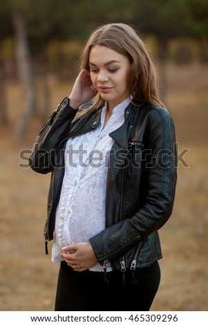 Pregnant young woman standing in the woods