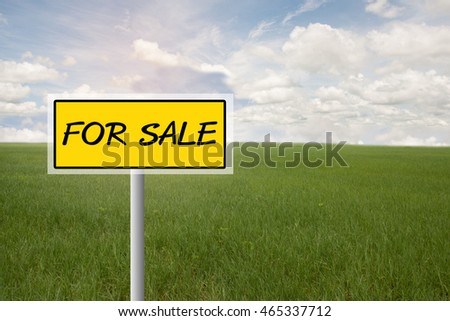 Real estate concept. Land For Sale signboard on the meadow under blue sky