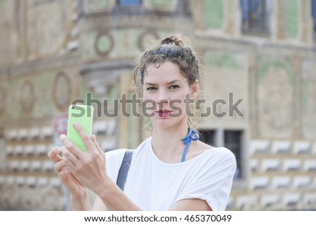 Young woman with her smart phone taking pictures.