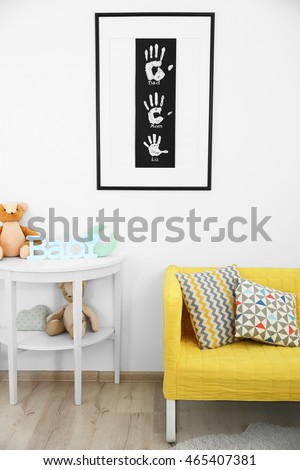Frame with family hand prints on wall in room