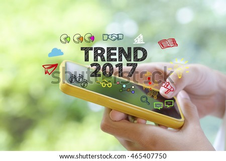 hand holding a smartphone with TREND 2017  concept , business concept