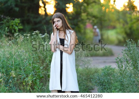 Woman with long hair and beautiful eyes on a green background shows the different human emotions. Lady portrays grief, sorrow, tears, hurt