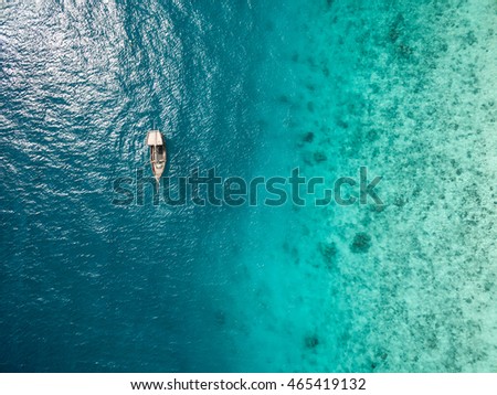 beautiful turquoise ocean water with boat on it top view aerial photo
