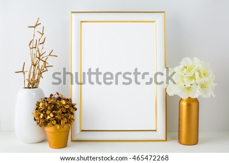 Frame mockup with ivory hydrangea in the  golden vase, white vase and golden flower pot. Poster white frame mockup. Empty white frame mockup for presentation artwork.