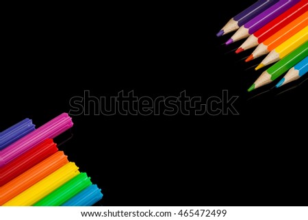 Lots of assorted colors marker pens and pencils with copyspace, on black glass background