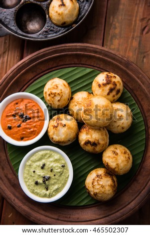 Appam or Mixed dal or Rava Appe served over moody background with green and red chutney. A Ball shape popular south Indian breakfast recipe. Selective focus
