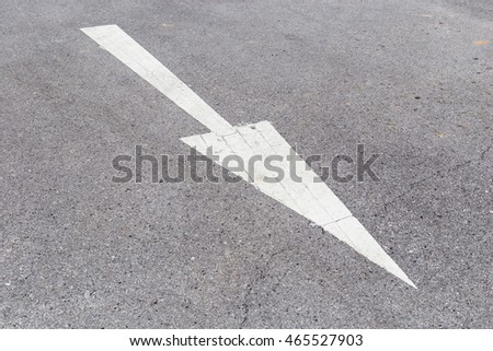 Arrow sign on asphalt