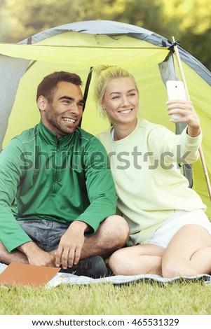 Picture showing couple camping in forest and taking selfie