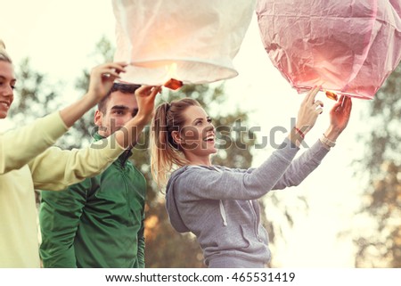 Picture showing group of friends floating chinese lanterns