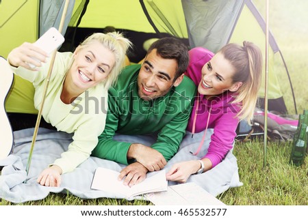 Picture showing group of friends camping in forest and taking selfie