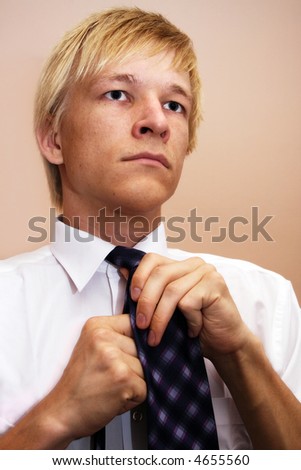 Businessman in white shirt arranging his tie