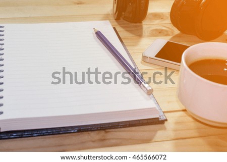 Planning and relax with coffee and blank notebook in sunlight on table background / copy space