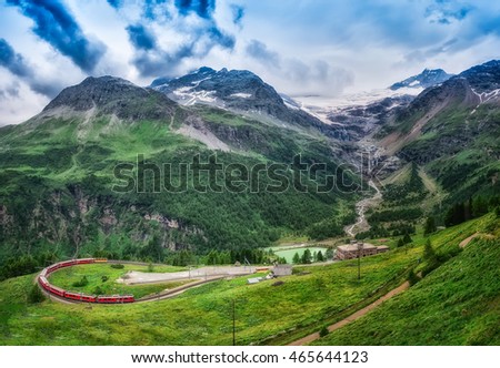 Red train Bernina Express to the passage in the mountains in the summer Royalty-Free Stock Photo #465644123
