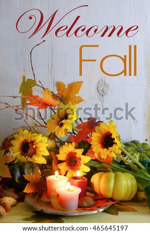 Fall still life with gourds, candles,  autumn leaves, twigs and sunflowers on a rustic wooden background with a vintage filter applied. Vertical orientation with message added