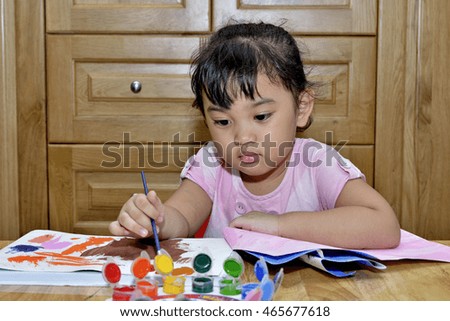 A cute young asian girl painting a picture