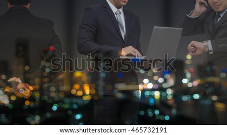 double exposure of Businessman group standing and working in night office over the cityscape photo blurred background, business hard working concept