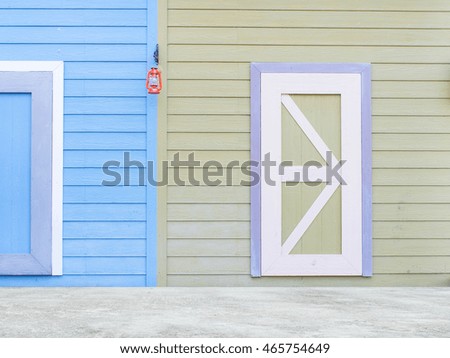 wooden wall and door with blue and green color in country style with light lamp and concrete floor.