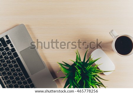 Mix of office supplies and gadgets on a wooden table background. 