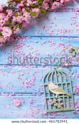 Background  with elegant  pink flowers on blue wooden planks. Flat lay. Selective focus. Place for text. Vertical image.