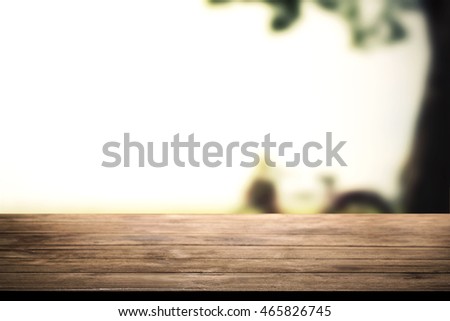 Empty wood table for display your product or advertise montage editing with blurry outdoor summer nature background.